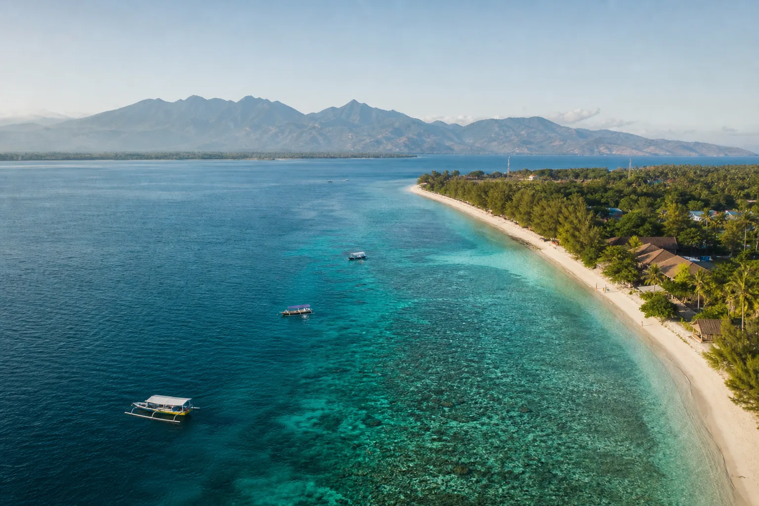 Aerial view of Gili Trawangan shoreline, coral reef and Lombok mountains